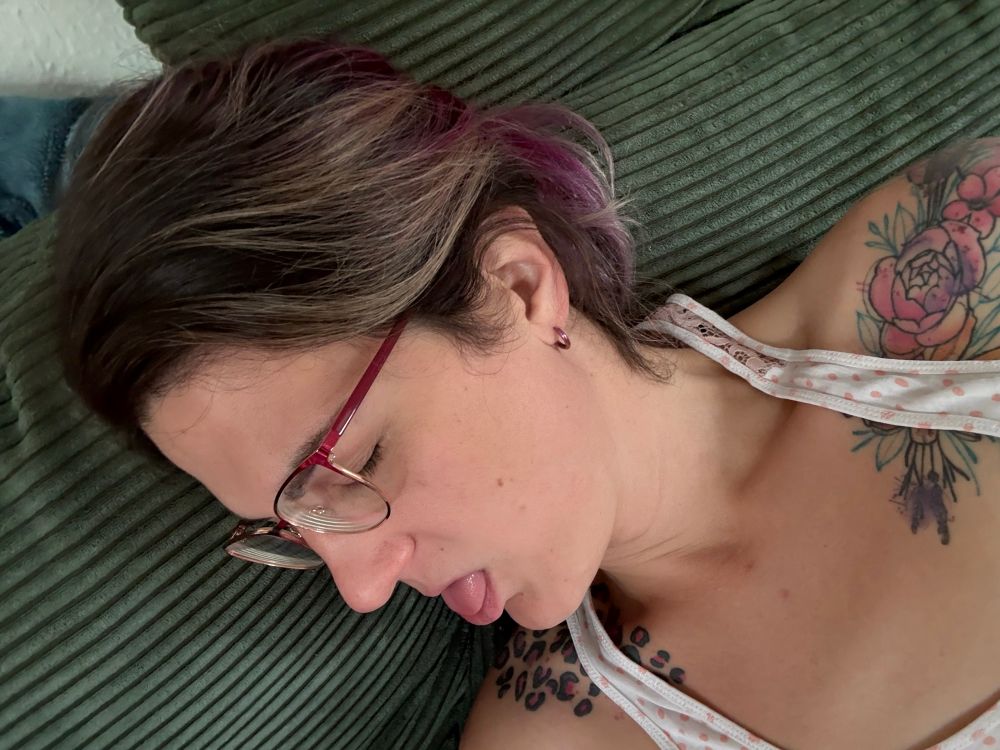 Cupcake, sick and uncomfortable, in her pajamas on her amazing green couch. This is a rare picture of her in glasses instead of contact lenses.