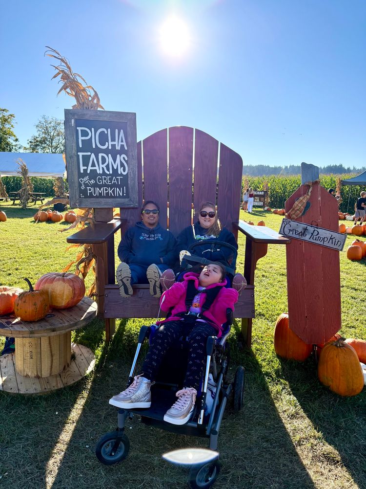 Amelia poses with her parents for a photo at the Picha Farms Pumpkin Patch