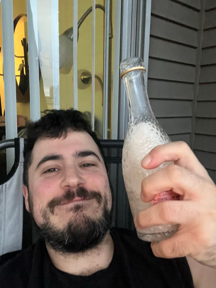 Me smiling with a mini bottle of champagne from a friend