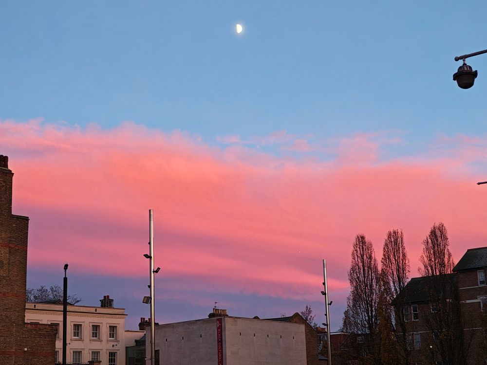 Pink clouds and moon at dusk photographed in Windrush Square, Brixton, London. 