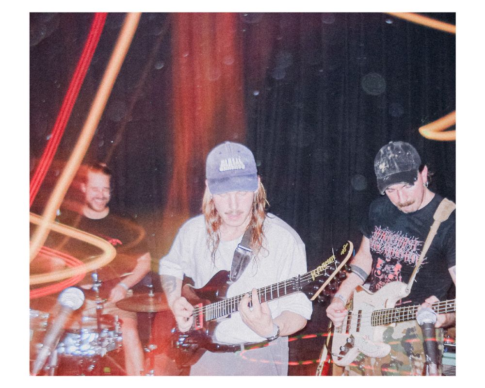 A guitar player at a concert. Streak of light across the person and flash blowing out the face. 