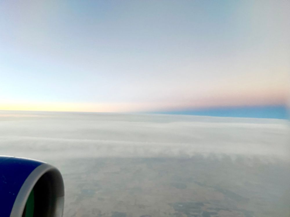 Image taken out of a 777 window at 35,000 feet altitude shows Earth's horizon curving away from a perfectly straight shadow line.