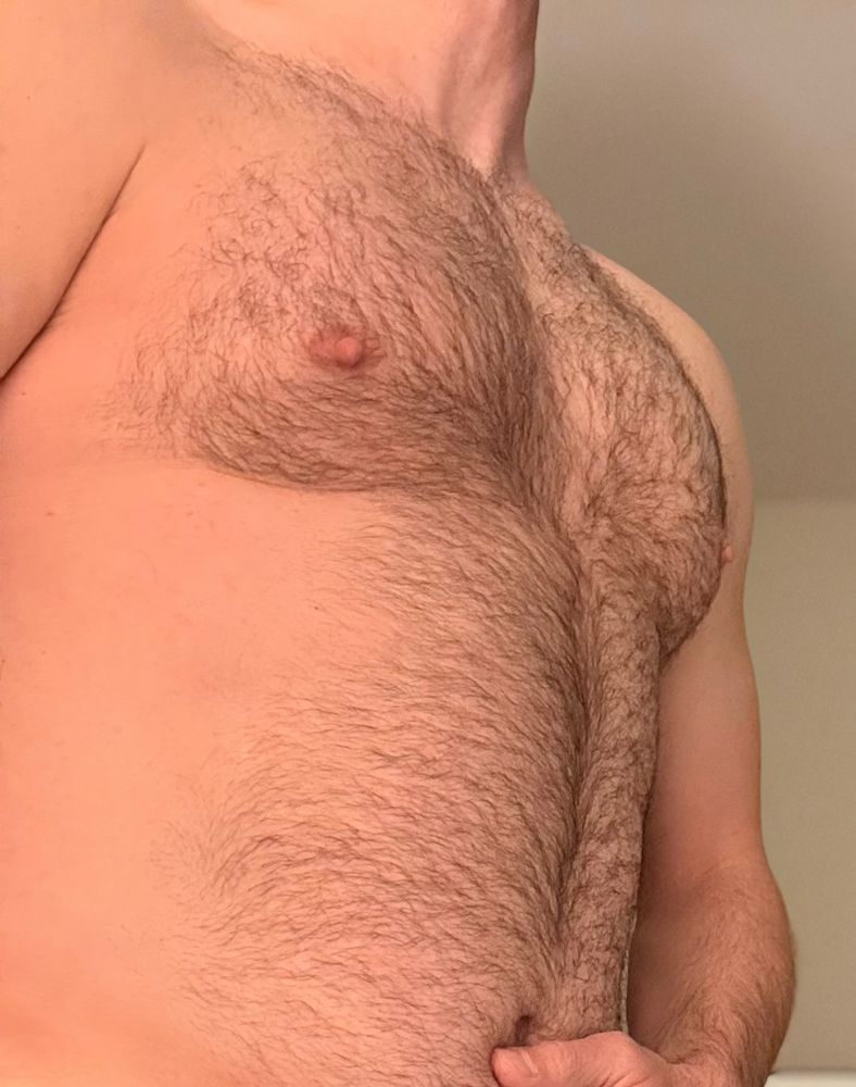 Side view of my body looking up at my hairy stomach and chest. 