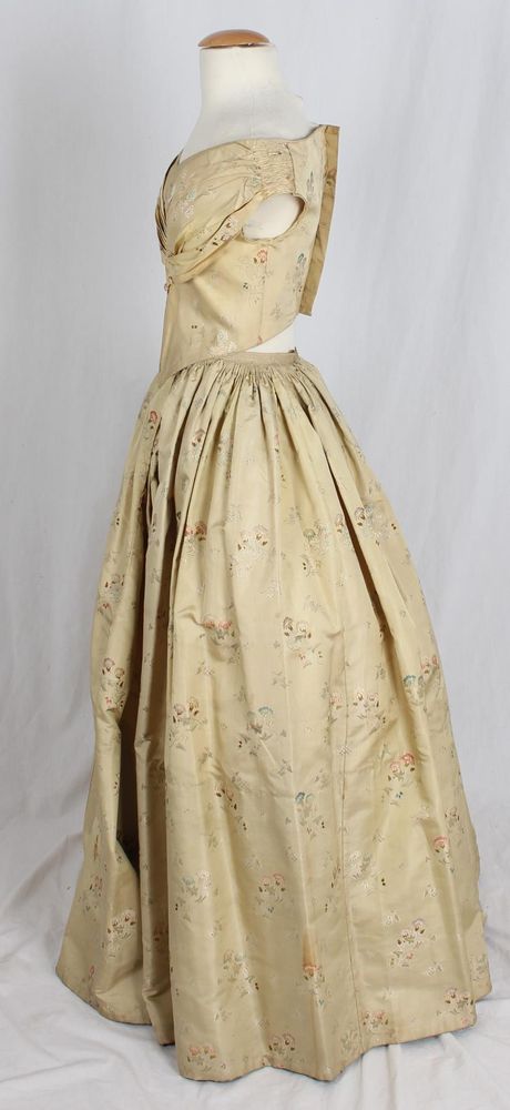 Dress with evening and day bodice of yellow brocade silk with woven multicolored pastel floral pattern: a) skirt: full skirt gathers at waist; b) evening bodice: pleated collar; sleeveless; CB hook closure; Basque style waist; c) day bodice: round neck, high collar; long straight sleeves; CF closure; fully lined.