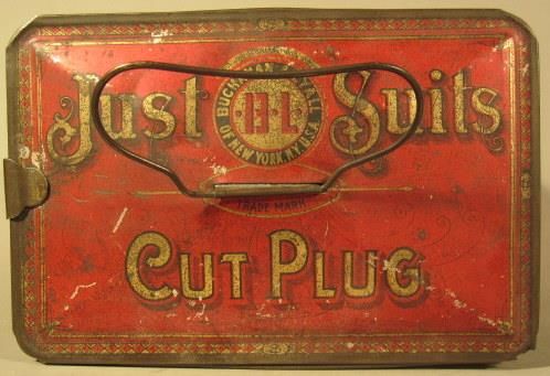Rectangular metal lunch box style tobacco tin with handle; red tin; "Just Suits / Cut Plug" in gold on lid above and below the Buchanan & Lyall logo; similar design on sides of tin.