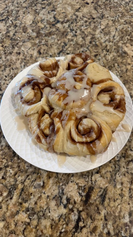 Plate of cinnamon rolls drizzled with icing