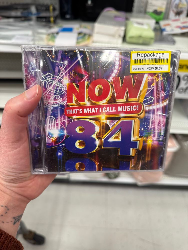 A photo of a CD case that reads Now That’s What I Call Music 84
