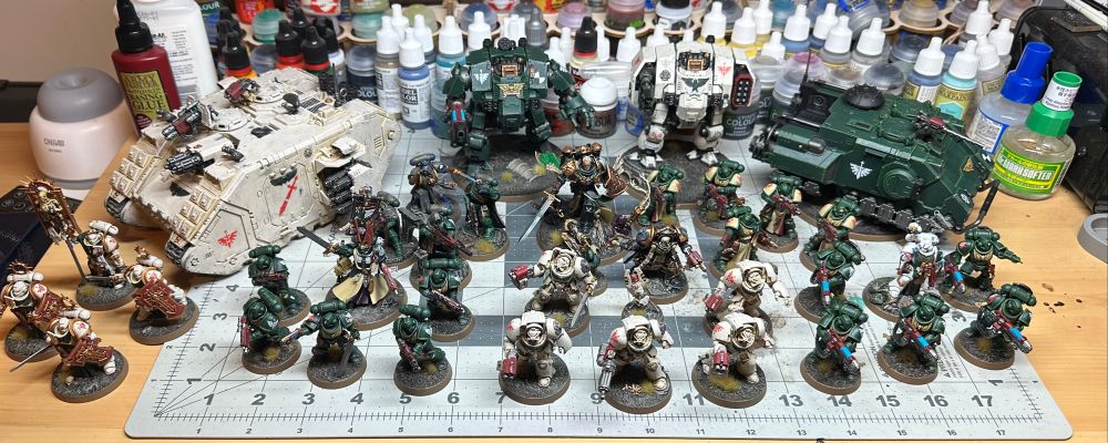 Group shot of a Warhammer 40K Dark Angels miniatures army on a hobby desk.
