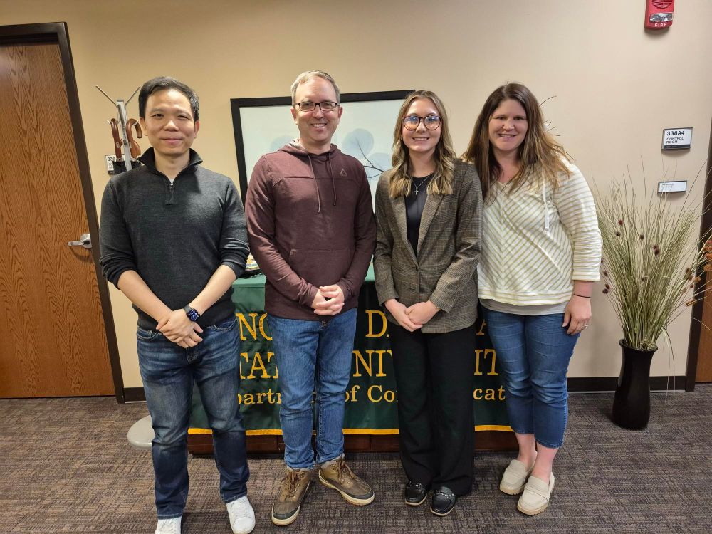 From left to right: Dr. Cheng Zeng, Dr. Stephenson Beck, MA graduate Ashlyn Schauer, and Dr. Kate Tulibaski, standing the Department of Communication's offices