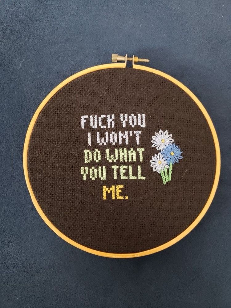 "Fuck you I won't do what you tell me," stitched in cross stitch.