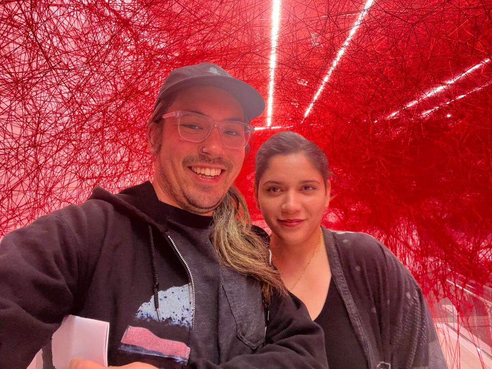 Nick and Britney smiling, standing inside of an art installation at the UCLA Hammer Museum.