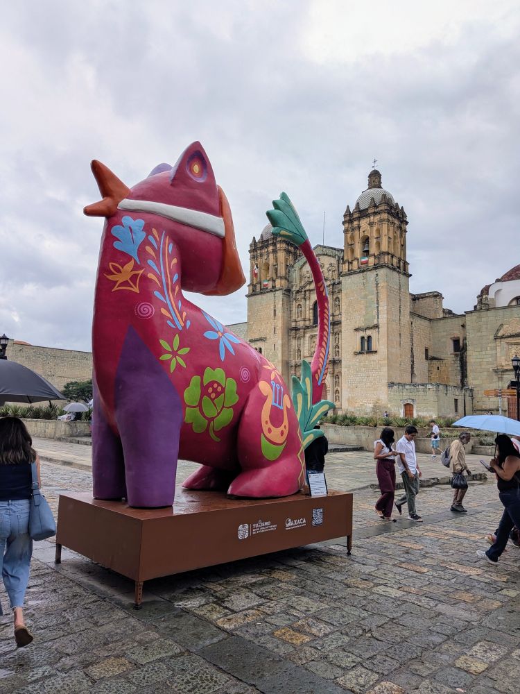 A colorful animal statue sits in the street in front of Santo Domingo Church.