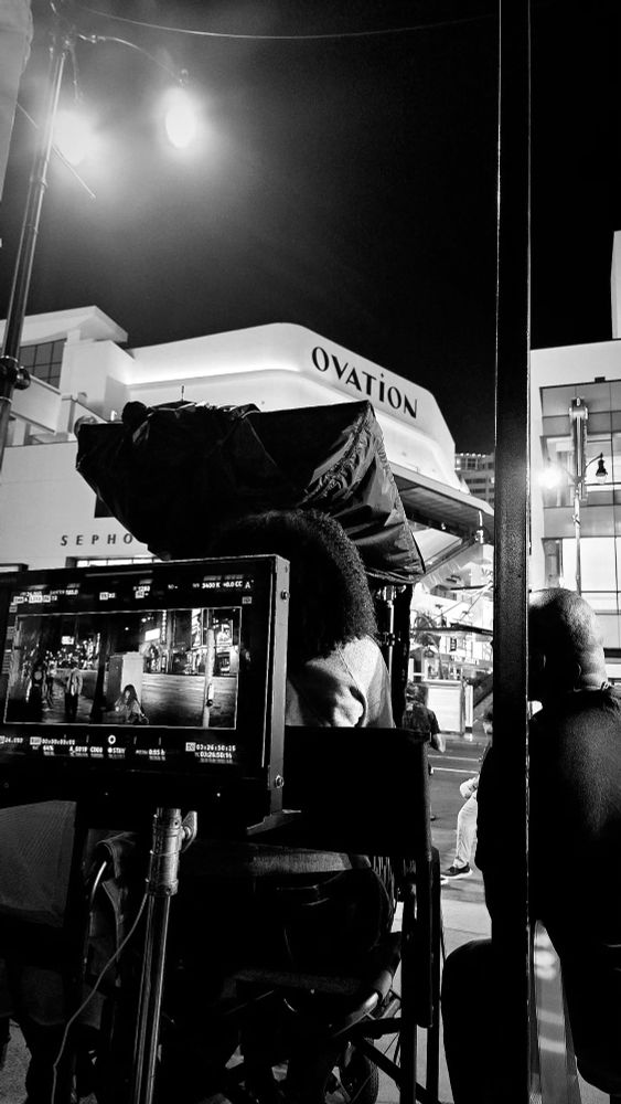 black and white behind the scenes pic showing a monitor with a snapshot of the scene being filmed on the set of Computer Blue/Misty Green with Chris Rock, Adam Driver, Rosalind Eleazar, Daniel Kaluuya & Anna Kendrick
