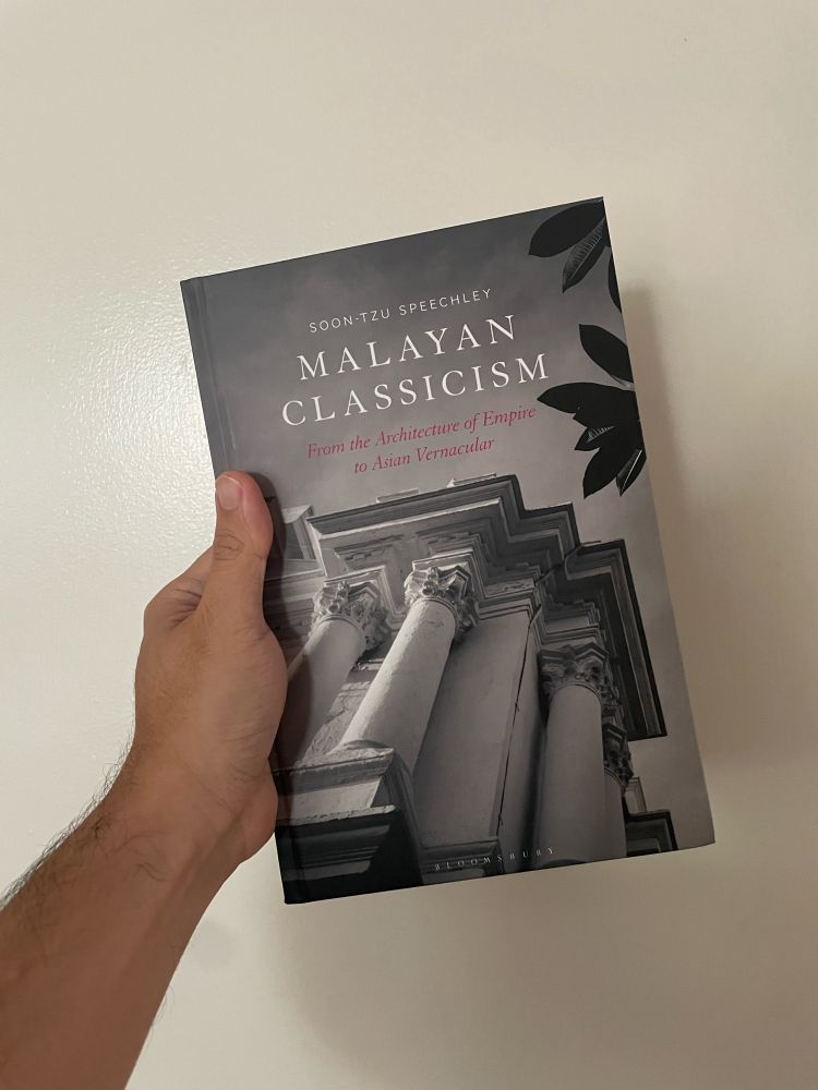 Hand holding the book Malayan Classicism