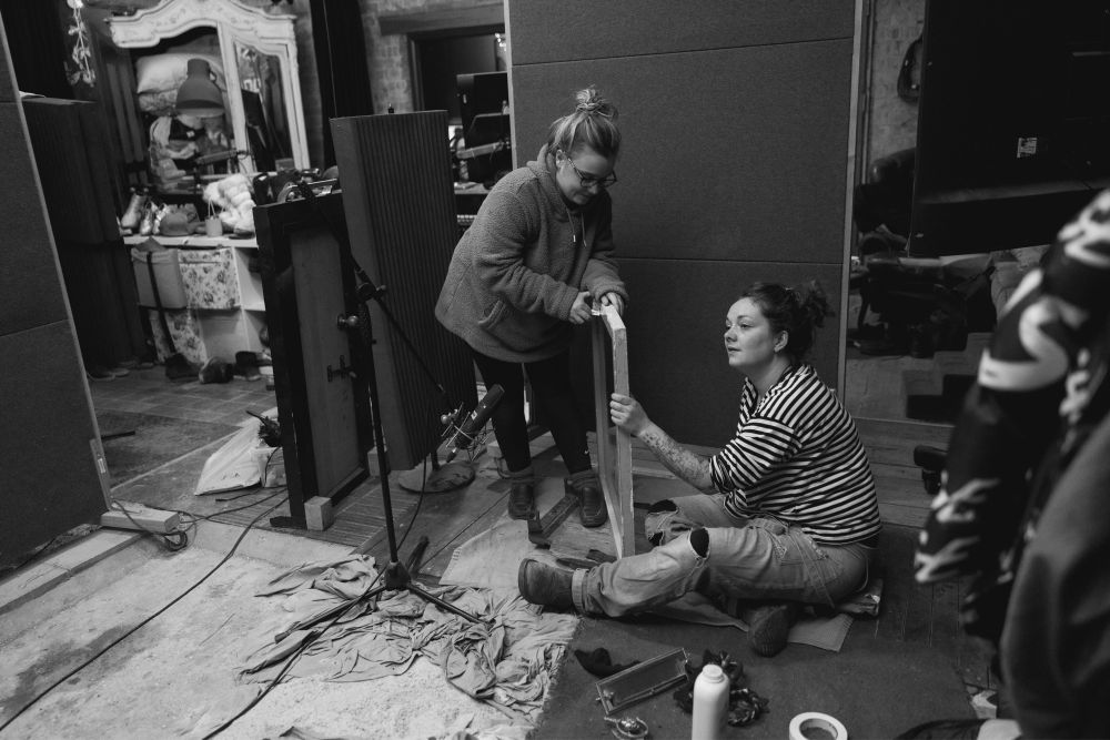 Foley Artists Rebecca Heathcote and Zoe Freed in front of a microphone recording a pane of glass for Netflix film That Christmas