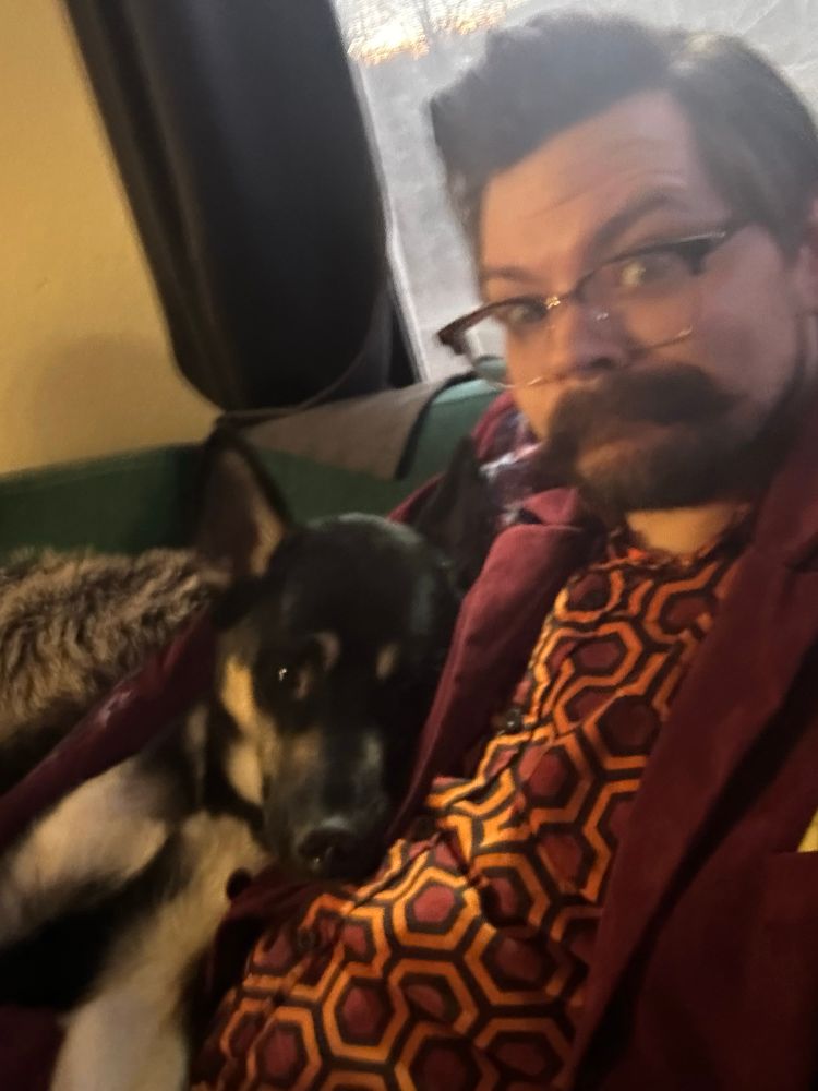 Selfie of Will on a couch and dog laying on him