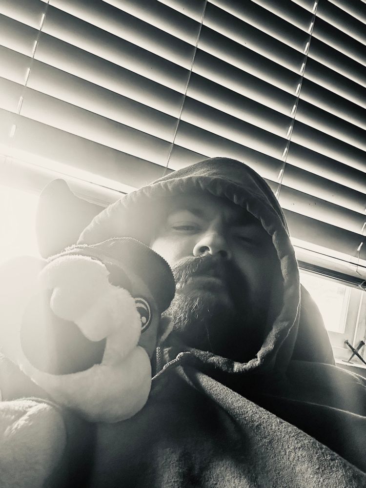 Will laying in bed looking grouchy with a Bucees plushie 