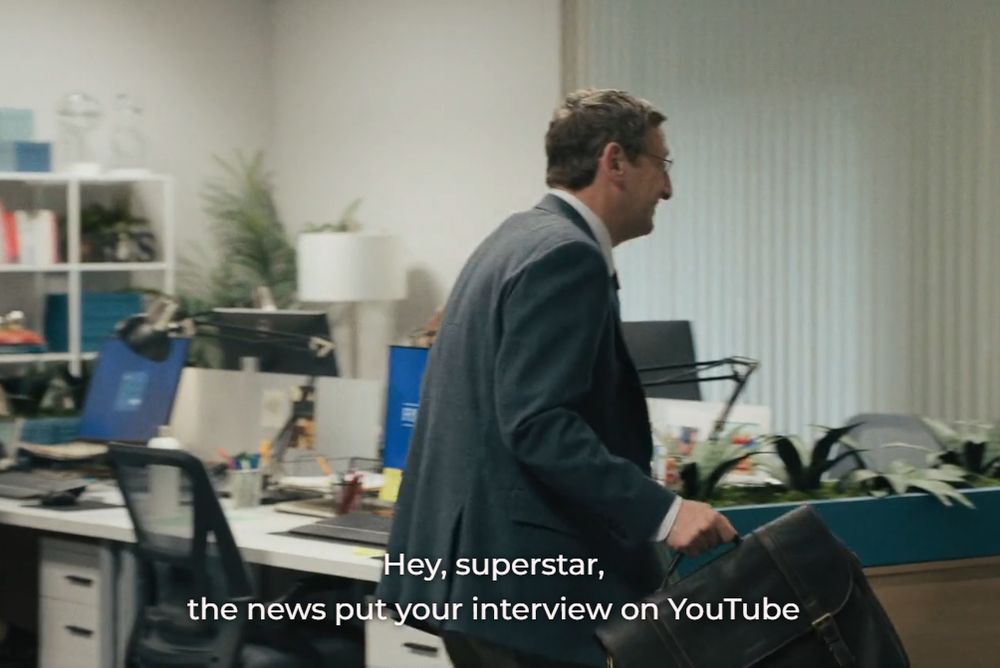 From the show The Chair Company. Ron walks through the office, someone offscreen says "Hey superstar, the news put your interview on YouTube"