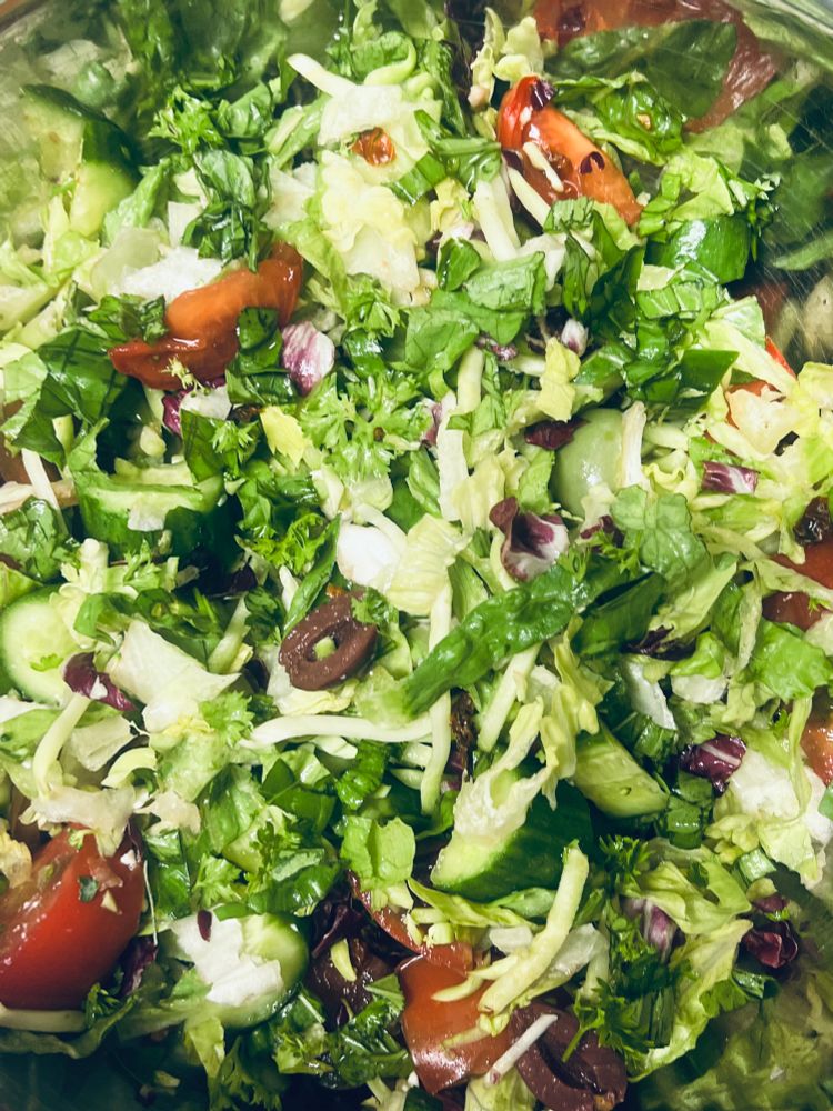 Chopped salad with tomatoes, cucumbers, olives, sun-dried tomato flakes, and feta.  