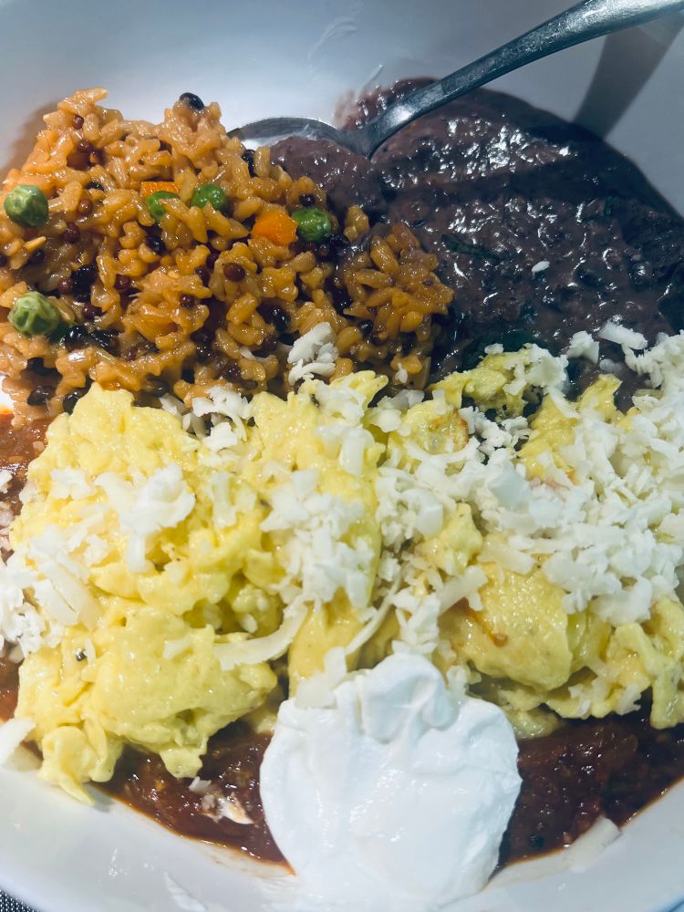 Scrambled soft eggs on ranchero sauce and topped with Monterey Jack cheese.  Served with refried black beans and a brown wild rice mix. Sour cream on the side.