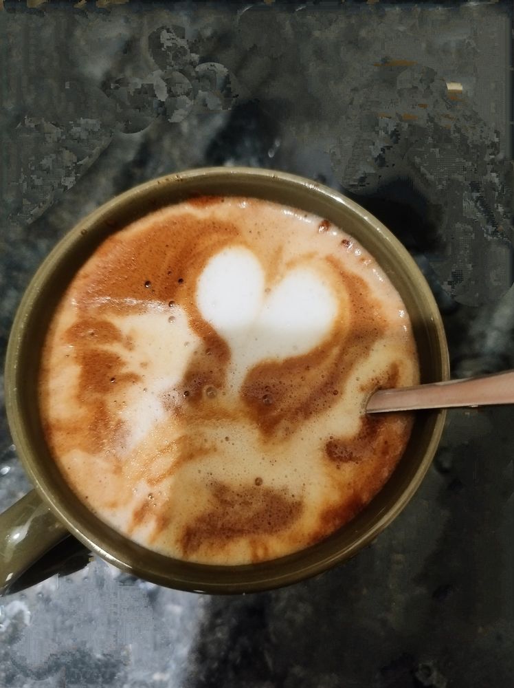 Coffee in a green cup with a single white rookie heart.