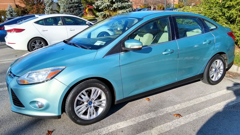Same 2012 Ford Focus sedan on a sunny day. The pale teal paint only looked good in bright sunlight.