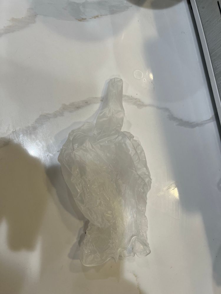 a white glove with its middle finger up against a white marble counter
