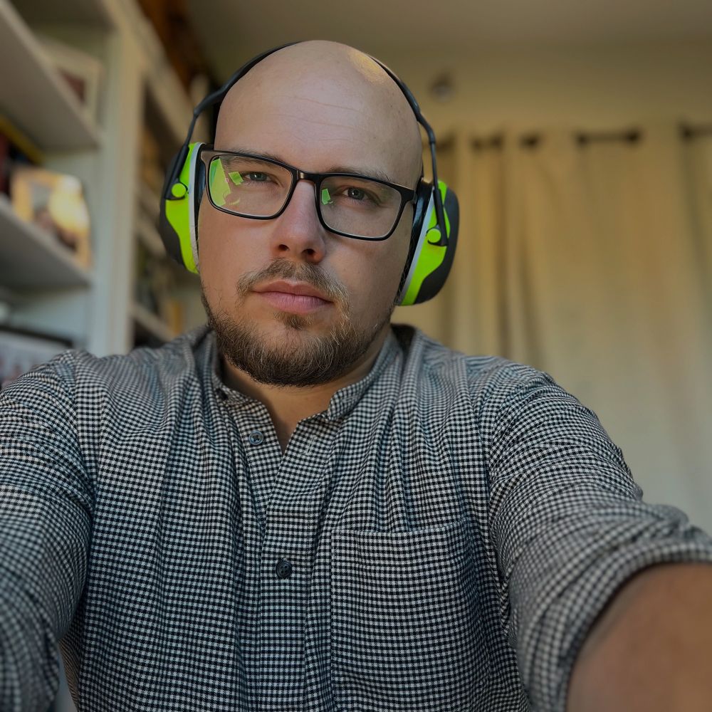 A ridiculous photo of Kit Sauder of Sauder Strategy wearing commercial grade noise cancelling headphones to help him focus with work. 