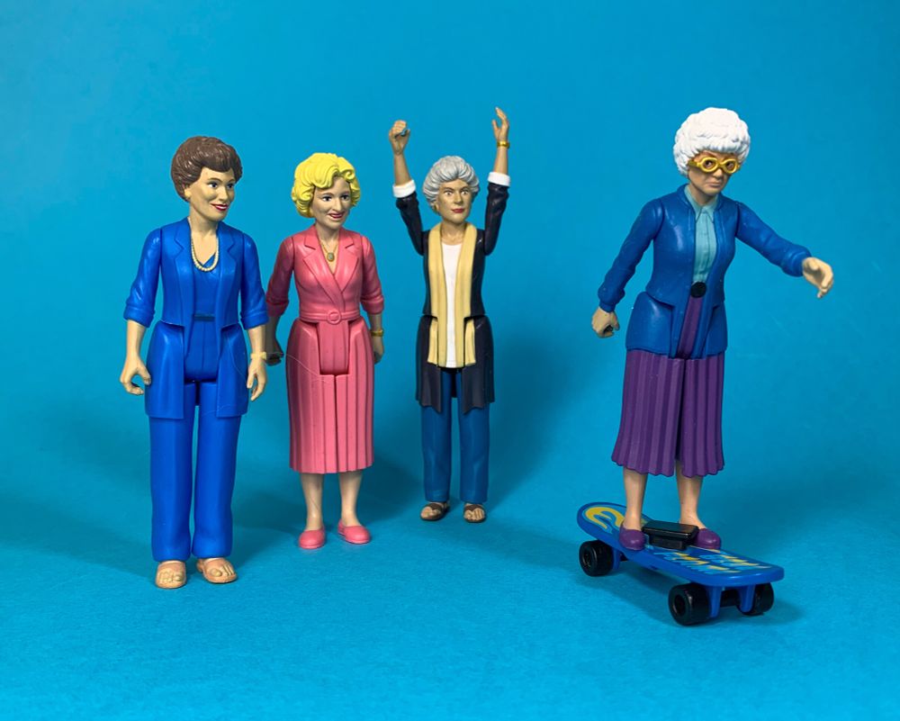 Four middle-aged ladies, one on a skateboard.