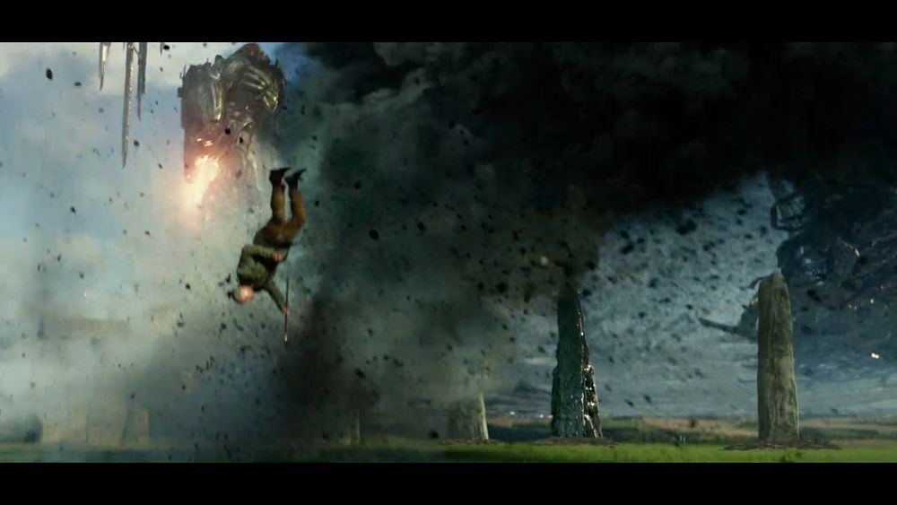 A still from the movie Transformers: The Last Knight, showing Anthony Hopkins ragdoll flipping in the air after getting blasted by a gun by Megatron. His surroundings is Stonehenge with some gun blasts and black smoke and other bullshit. Megatron is flying away in the background. There's too much fucking bullshit in this frame, it looks awful