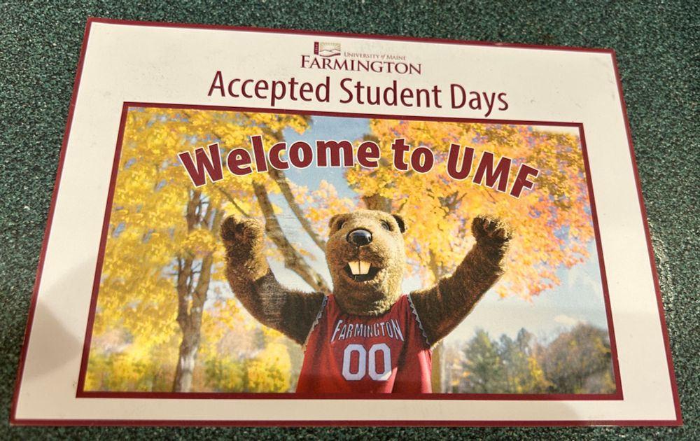 Text says: Accepted students day to University of Maine Farmington.  Photo is of a Beaver mascot with fall trees as a background 
