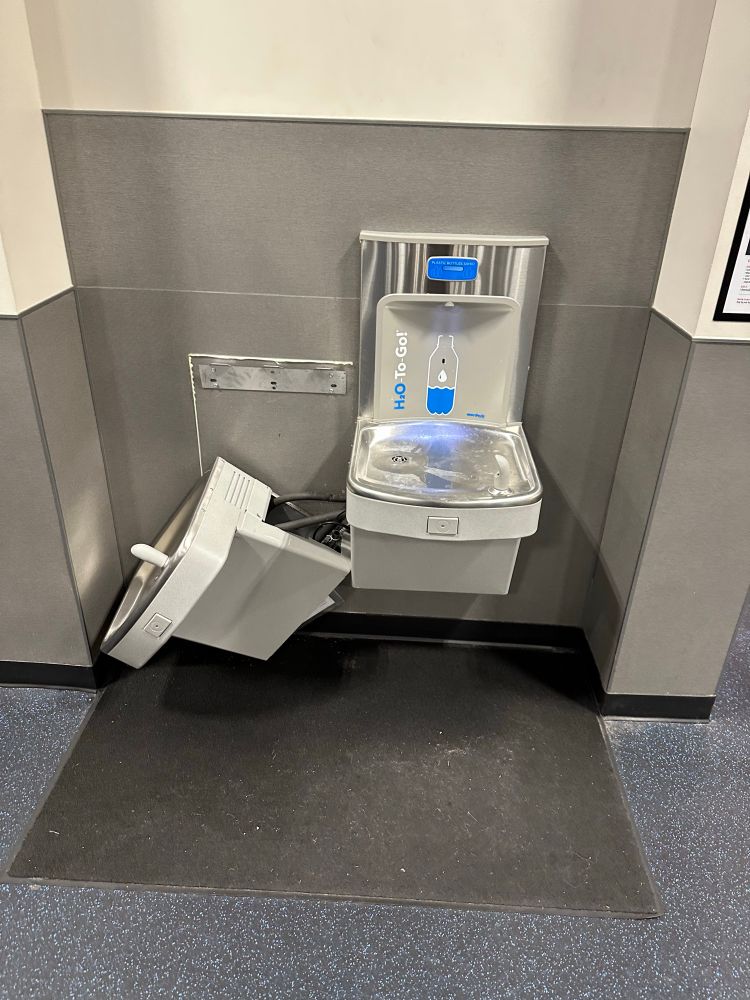 Two water fountains are present, where one has been knocked down and broken. 