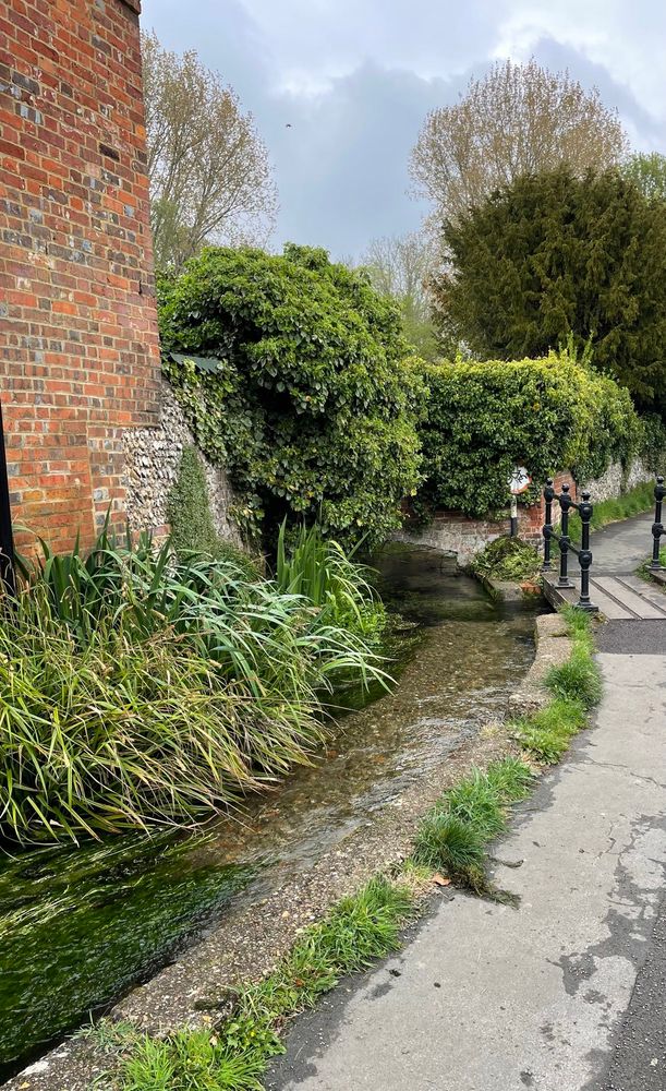 An unfenced stream running alongside a footpath by the Queens Head pub in poverty-stricken Chesham