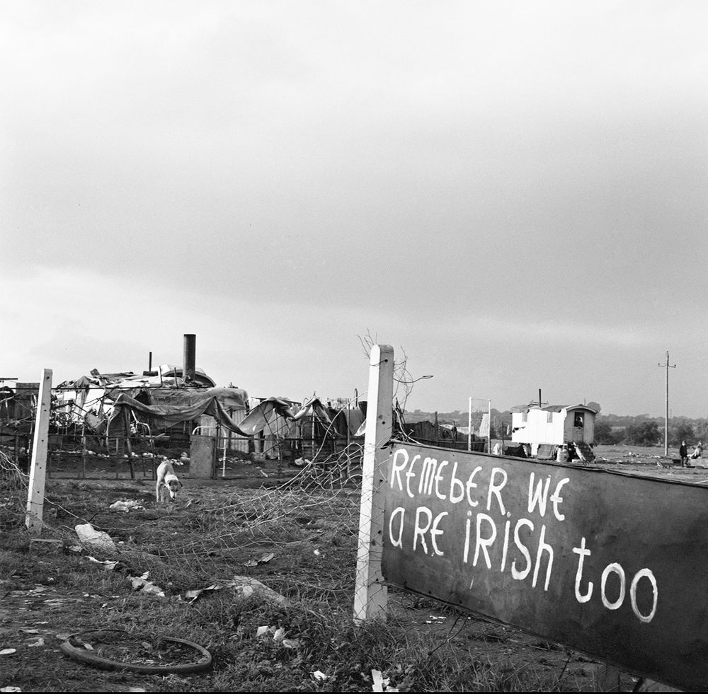 Image of a Traveller site. Sign at the front saying ‘remember we are Irish too