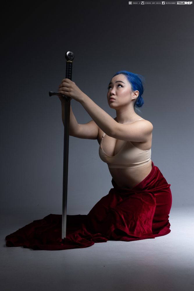 Art pose reference of a woman kneeling with a sword. 