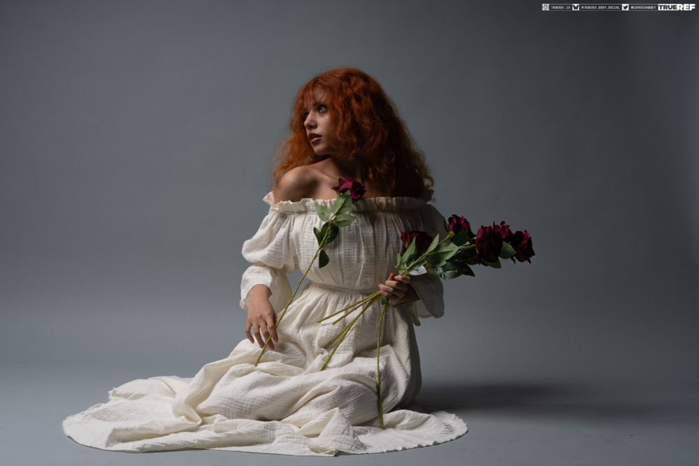 Art pose reference of woman sitting on the floor with flowers 