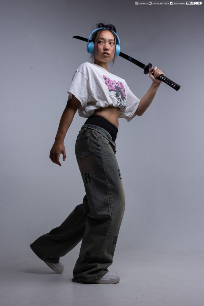 Art pose reference of a woman in street clothes holding a sword. 