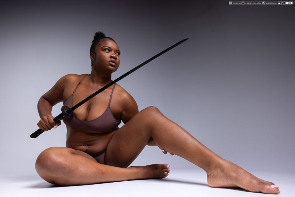 art pose reference of a woman laying on the floor holding a sword.