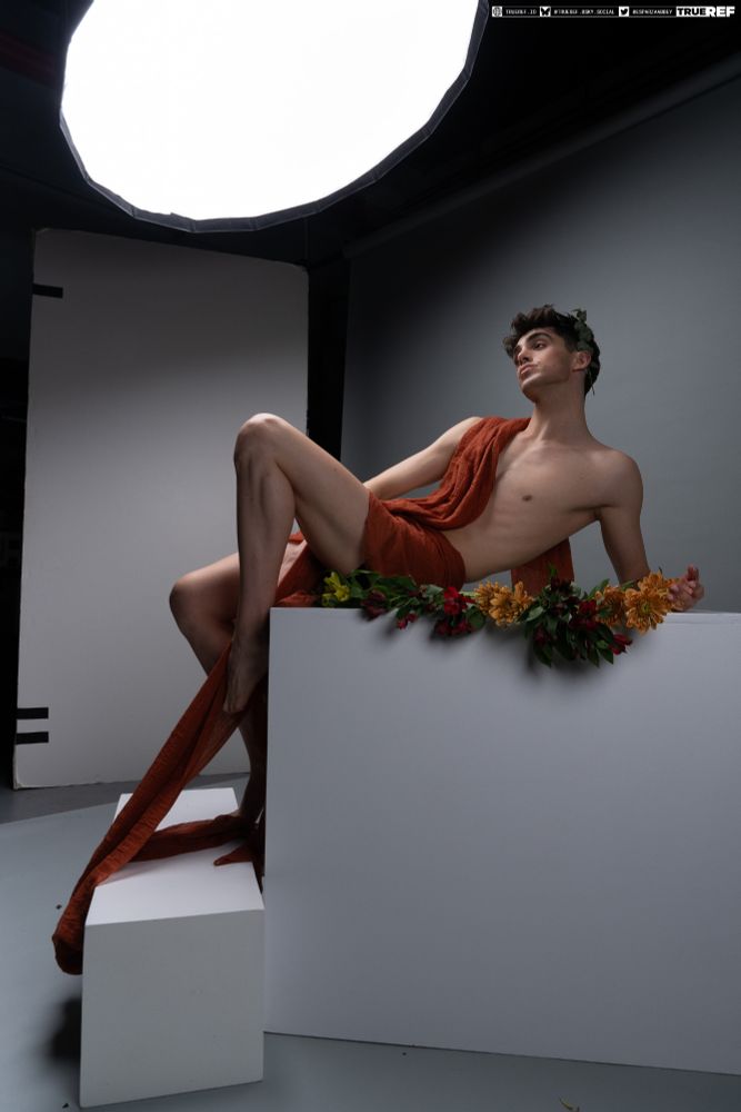 Art reference of a man laying down while draped in red baric. 