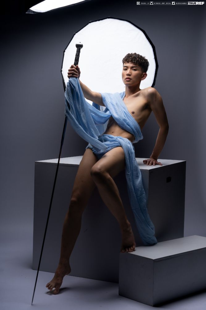 art reference of a young male wrapped in blue fabric with a sword. 