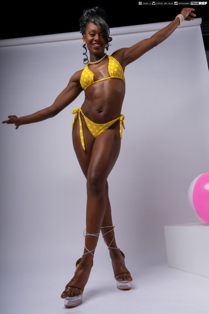 art pose reference of a woman in a yellow bikini  smiling at the camera with her arms in the air. 