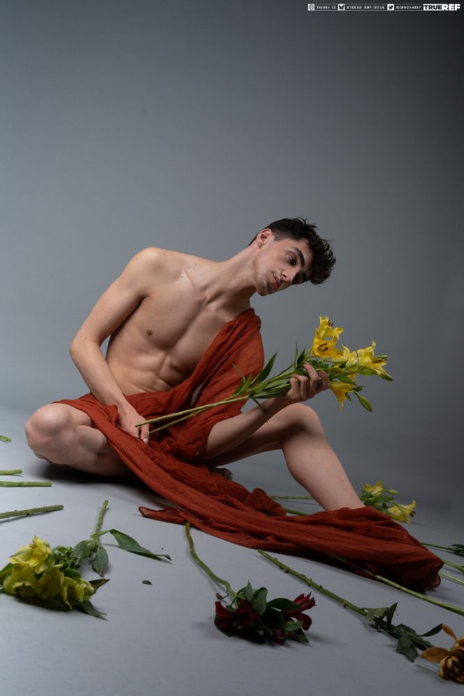 Art reference of a man sitting while draped in red baric. 