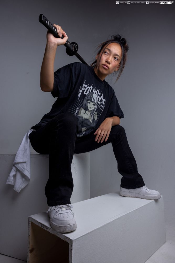 Art pose reference of a woman in street clothes holding a sword. 