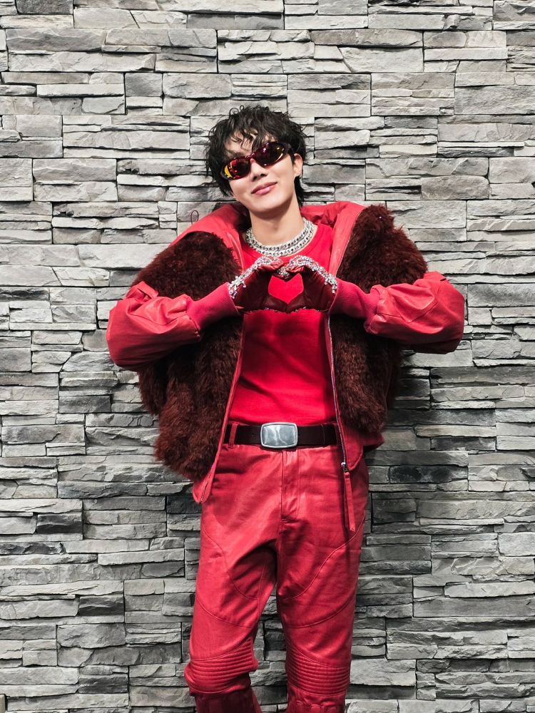 Hobi in his red stage outfit making a heart