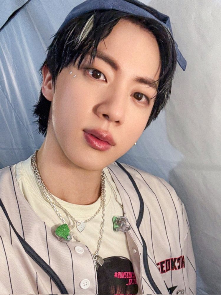 Seokjin in his merch: face tee, baseball jersey + backwards 🧢 