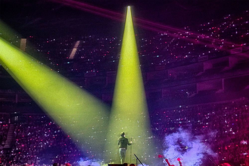 Seokjin on stage with ARMY in the background 
