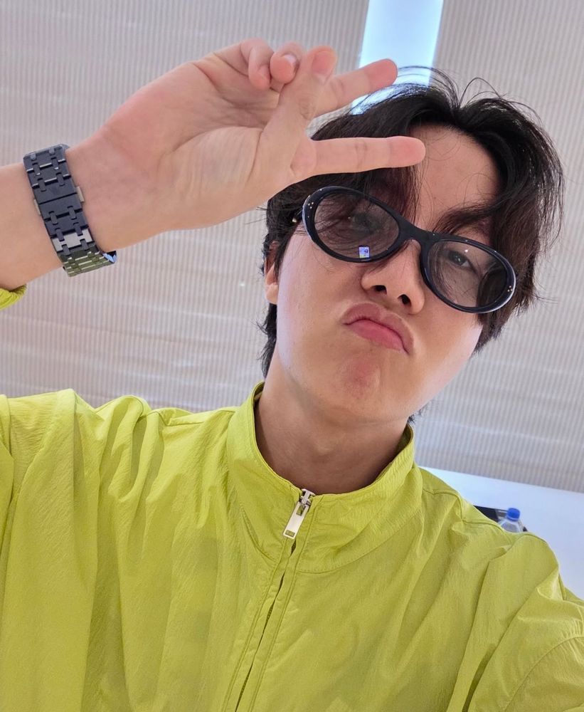 Hobi in neon windbreaker and sunglasses pouting