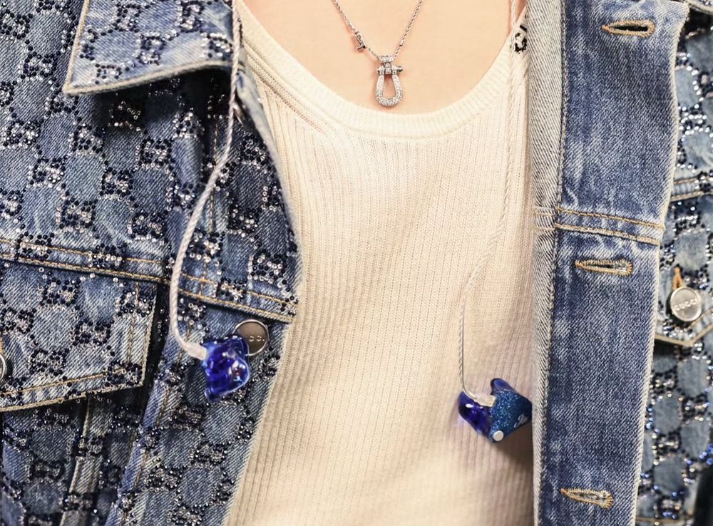 Captured from the front, showing the denim detail / thread over his ribbed white tanktop. His IEM dangle over his chest along with his diamond necklace by FRED Jewelry. 