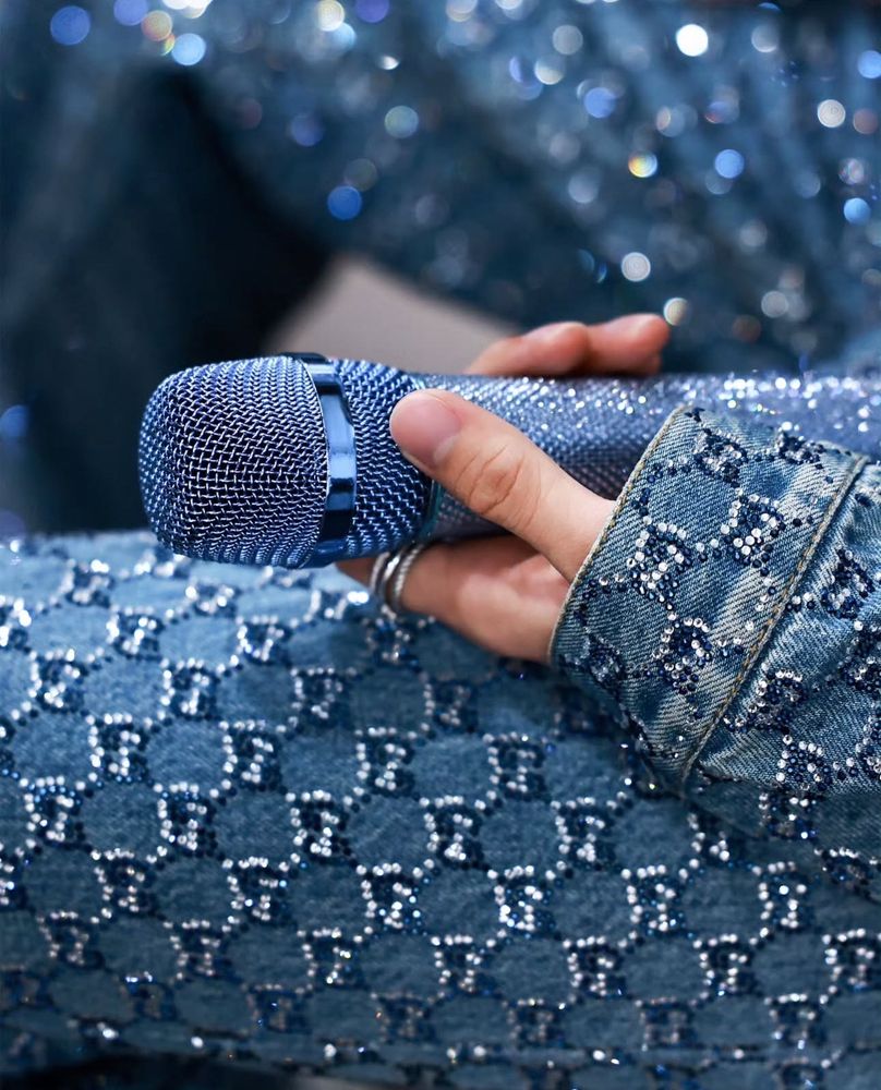 The blue and white sparkly rhinestones detail; captured with his hand holding onto his equally sparkly blue microphone. 