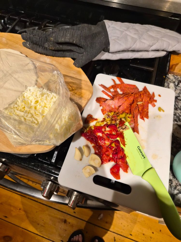 Pizza toppings ready to be assembled and a big ass pair of oven gloves 
